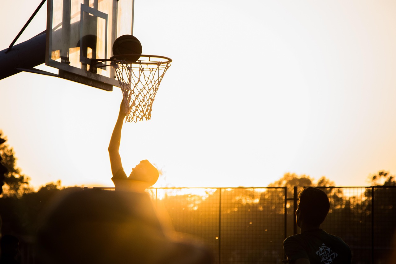 Basketspelare i rullstol gör mål i solnedgången.